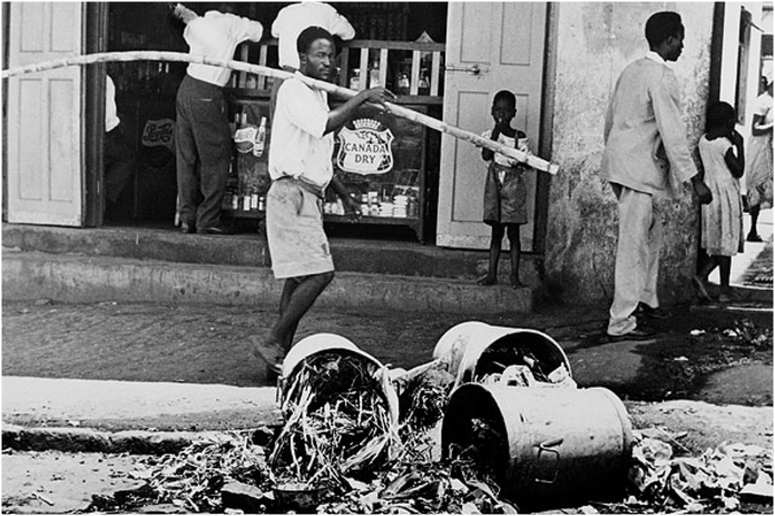 A man passes by overturned garbage cans on the streets, March 18, 1962 as Trade Unions call for a current strike in order of putting pressure on on constitutional talks in London for the colony's independence. Independence of Kenya was declared on December 12, 1963.